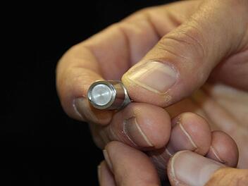 Der Sensor (großes Foto, oben) schickt Ultraschallwellen ins Wälzlager und misst anhand des Echos den Schmiermittelzustand.