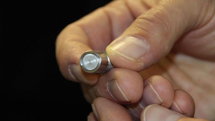 Der Sensor (großes Foto, oben) schickt Ultraschallwellen ins Wälzlager und misst anhand des Echos den Schmiermittelzustand.