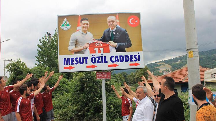 Das Plakat im türkischen Devrek zeigt Özil mit Erdogan bei einem Termin in London. Die Pfeile unter dem Plakat deuten in Richtung der "Mesut-Özil-Straße". Die Straße wurde 2012 nach dem Arsenal-Profi benannt. Foto: Muharrem Terzi/dpa