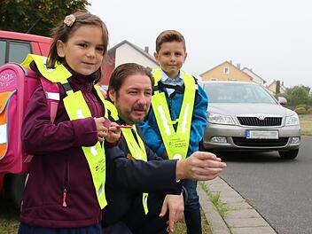 Verkehrserzieher Matthias Kleren erklärt zum Schulstart den beiden Abc-Schützen Leni und Timo das richtige Verhalten im Straßenverkehr. Ein Tipp: Nie zwischen parkenden Autos hindurch auf die Straße laufen.