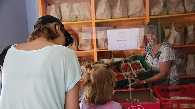 Ilse Schneider verteilt im Tafel-Laden Obst und Gem&uuml;se, hier an eine Ukrainerin mit ihrer kleinen Tochter.&nbsp;