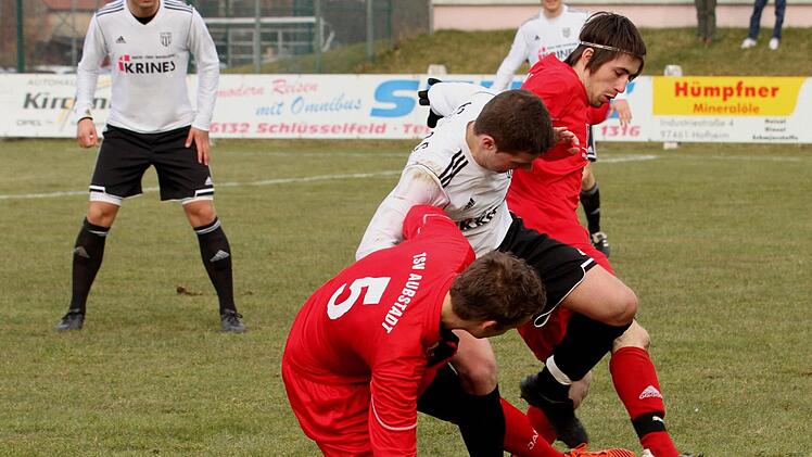 In die Zange nehmen die beiden Aubstadter den Sander Fabian Benkert, links Gästestopper Christoph Rützel.