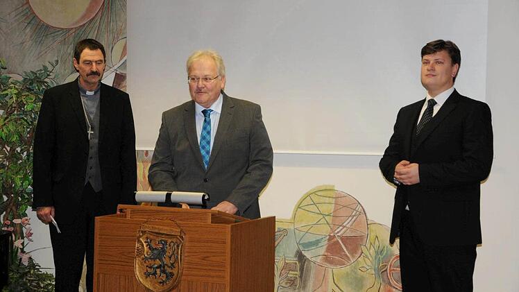 Bürgermeister Claus Bittenbrünn (Mitte) hieß den neuen evangelischen Pfarrer für Königsberg und Unfinden, Peter Hohlweg (rechts) willkommen und versprach ihm ein herzliches Miteinander. Links ist Dekan Jürgen Blechschmidt. Foto: Gerold Snater
