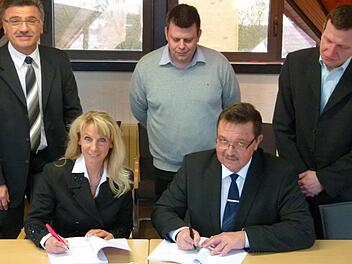 Marion Thüngen (Telekom) und Bürgermeister Jürgen Wittmann (vorne) unterzeichnen den Kooperationsvertrag im Beisein von (hinten von links) Klaus Markert (Telekom),dem Breitbandpaten André Fischer und Martin Reuter (Planer). Foto: Lothar Weidner