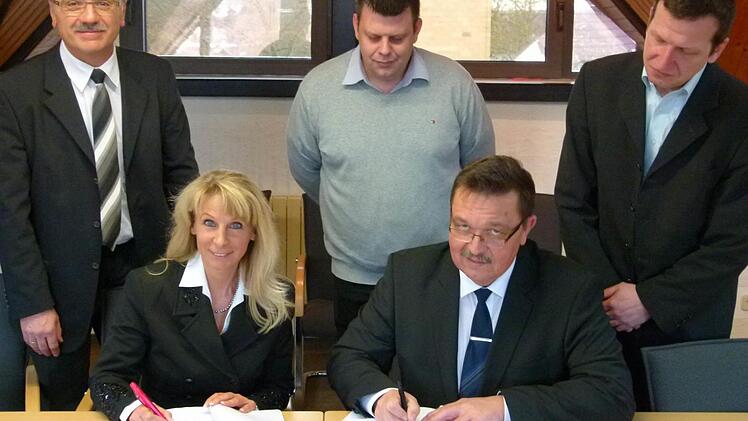 Marion Thüngen (Telekom) und Bürgermeister Jürgen Wittmann (vorne) unterzeichnen den Kooperationsvertrag im Beisein von (hinten von links) Klaus Markert (Telekom),dem Breitbandpaten André Fischer und Martin Reuter (Planer). Foto: Lothar Weidner