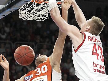 Leon Radosevic h&auml;mmert den Ball mit viel Energie in den Korb. Der Ulmer David Brembley (l.) hat das Nachsehen.  Foto: sportpress