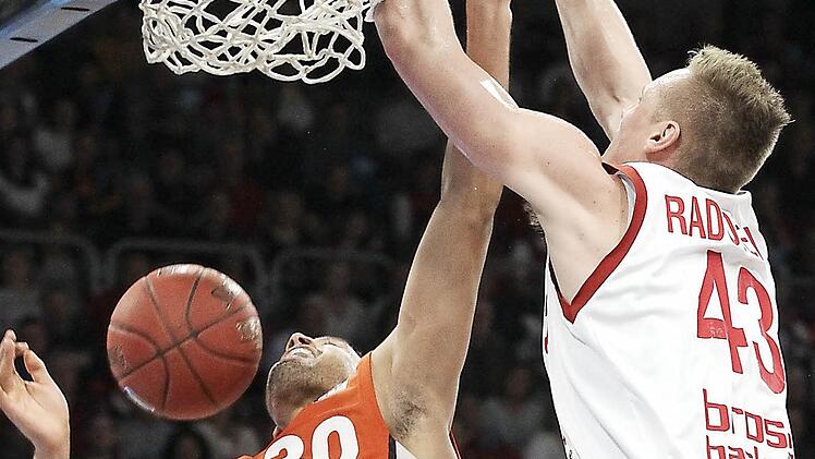 Leon Radosevic h&auml;mmert den Ball mit viel Energie in den Korb. Der Ulmer David Brembley (l.) hat das Nachsehen.  Foto: sportpress