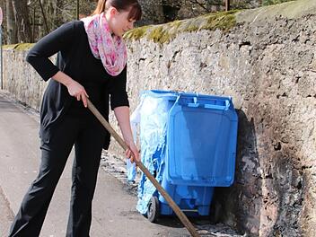 Anna Holzheimer versucht, die geschmolzenen Reste der M&uuml;lltonne zu entfernen.  Foto: Thomas Malz