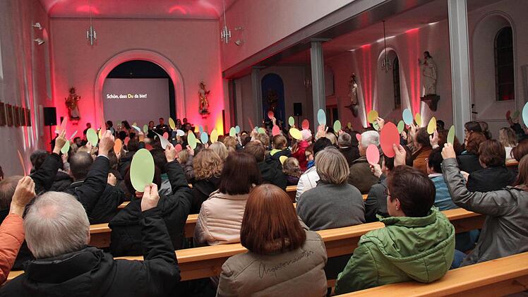 Ein bunt gemischtes Publikum (rechts oben) war am Samstag Abend in der in ebenfalls buntes Licht getauchten Aischer Kirche zu sehen. Fotos: Johanna Blum