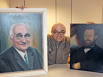 Kurator Stefan Andritschke eingerahmt von Porträts mit "Papa" (Otto) Schäfer, der das Kugelfischer-Werk in Ebern zur Blüte brachte (links) und einem Mann namens Wilhelm Schneider, womit nicht der aktuelle Landrat, sondern ein Kaufmann aus Untermerzbach gemeint ist. Foto: Ralf Kestel