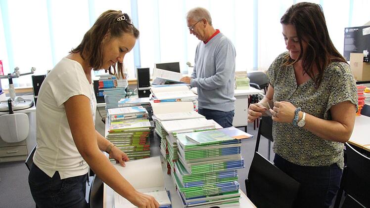 Stempeln, katalogisieren, stapeln: Juliane Holzner und Silke Budnikov (v.l.), Lehrerinnen an der Ritter-von-Spix-Mittelschule, sind für die Lehrmittelverwaltung zuständig. Heuer mussten besonders viele neue Schulbücher bestellt werden, sagt Rektor Michael Ulbrich (Mitte).