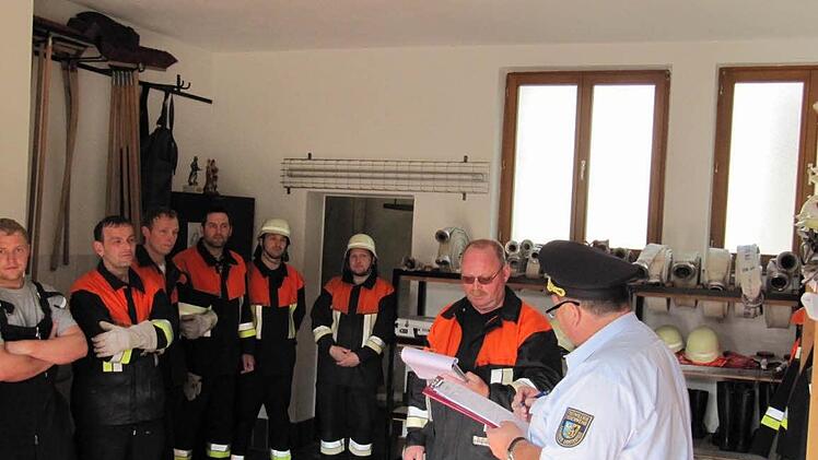 Im Feuerwehrhaus: Kreisbrandinspektor Gerhard Elflein(re) erkundigt sich auch nach der Ausrüstung und Mannschaftsstärke .