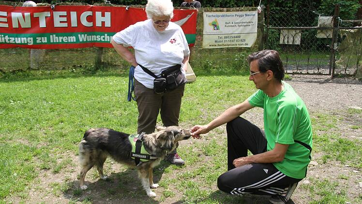 Angelika Müller aus Presseck freut sich, dass ihr rumänischer Fundhund Mandy Trainer Rafael Lopez aus der Hand frisst: Er lässt sich normalerweise nicht anfassen.