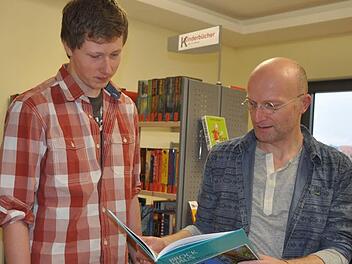 Hubert Ziegler (rechts) zeigt Patrick Kuder ein Buch, das ihn interessieren k&ouml;nnte. Foto: Arthur Stollberger/Archiv