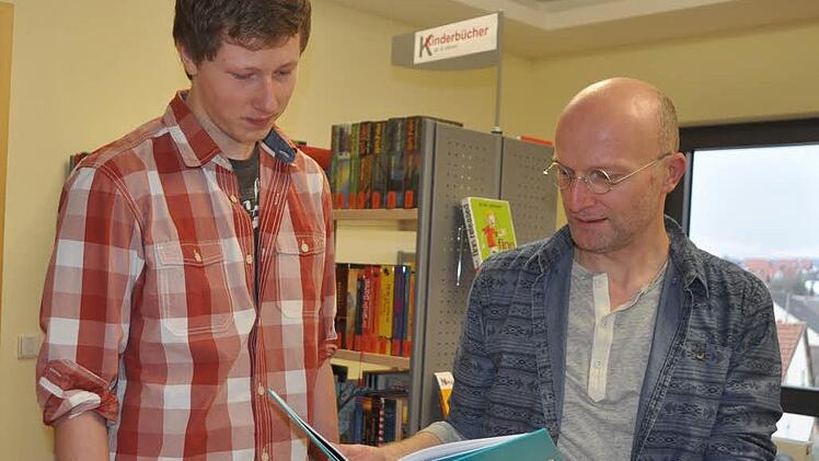 Hubert Ziegler (rechts) zeigt Patrick Kuder ein Buch, das ihn interessieren k&ouml;nnte. Foto: Arthur Stollberger/Archiv