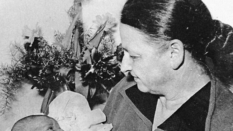 Die Hebamme Margareta Schneider (1907 - 1991) , die sie voller Stolz mit einem Baby zeigt. Möglicherweise könnte es ihre Enkelin sein, die sie im Arm hält. Sie wohnte im Lehenthaler Weg 18.