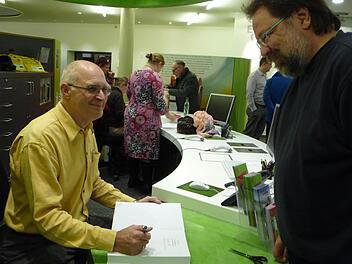 Reinhold Glas (l.) unterschreibt sein jüngst erschienenes Buch.  Foto: Elisabeth Görner
