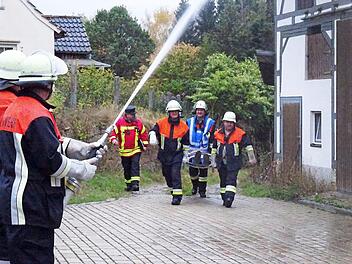 Rettungskräfte der Feuerwehr tragen die Verletzte aus dem Gefahrenbereich, während die Löscharbeiten in vollem Gange sind. Foto: Feuerwehr