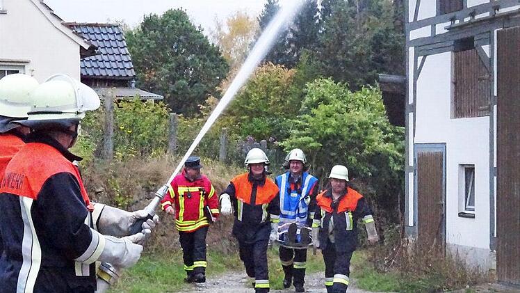 Rettungskräfte der Feuerwehr tragen die Verletzte aus dem Gefahrenbereich, während die Löscharbeiten in vollem Gange sind. Foto: Feuerwehr