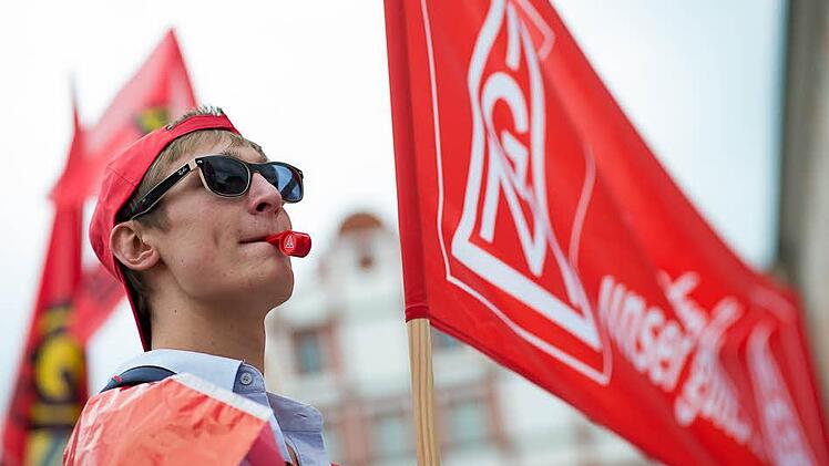 Ein Auszubildender untermauert mit Trillerpfeife und Transparent die Forderung nach mehr Entgelt und einer Erhöhung der Ausbildungsvergütung.