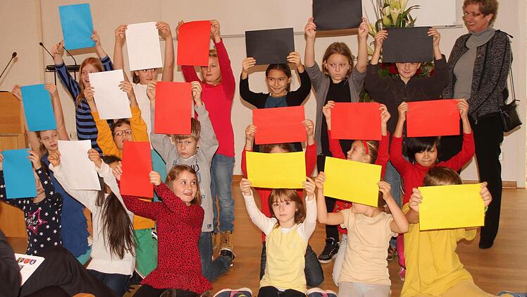 Die Schüler der Grundschule Haßfurt überraschten mit einem französischem Lied, beim dem am Schluss die Farben der beidenNationalflaggen zum Vorschein kamen.  Fotos: Günther Geiling