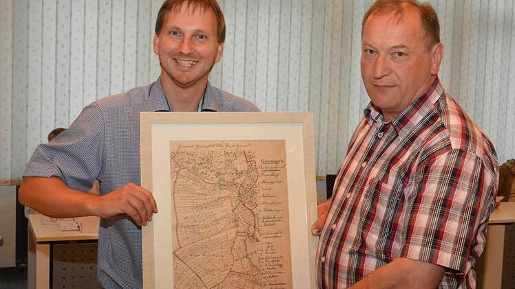 Bürgermeister Wolfram Thein (links) verabschiedete den bisherigen Ortssprecher von Gresselgrund, Helmut Schad (rechts) mit einem alten Stich von Gresselgrund. Schad gehörte seit 1996 dem Gemeinderat in Maroldsweisach an. Bürgermeister Thein dankte dem langjährigen Ortssprecher, der unter anderem beim Hüttenbau und Anlegung des Spielplatzes seine Handschrift hinterließ. Foto: Schmidt