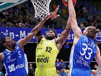 Der Bayreuther Center Hassan Martin (Mitte) überragte beim Sieg in Frankfurt. Er erzielte 20 Punkte, kam auf sechs Rebounds und acht geblockte Würfe. Links Jason Clark, rechts Marco Völler. Foto: Eibner