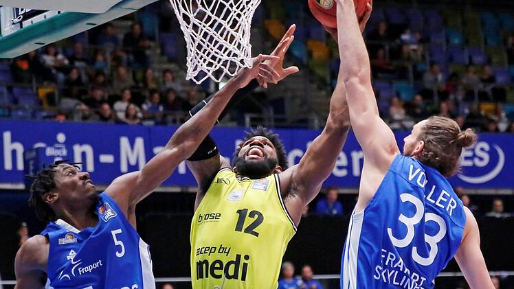 Der Bayreuther Center Hassan Martin (Mitte) überragte beim Sieg in Frankfurt. Er erzielte 20 Punkte, kam auf sechs Rebounds und acht geblockte Würfe. Links Jason Clark, rechts Marco Völler. Foto: Eibner