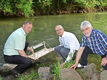 Landrat Thomas Bold, Niederlauers Bürgermeister Richard Kneier und Bad Bocklets Bürgermeister Wolfgang Back lassen traditionell das Saale-Musicum-Floß zu Wasser. Fotos: Björn Hein