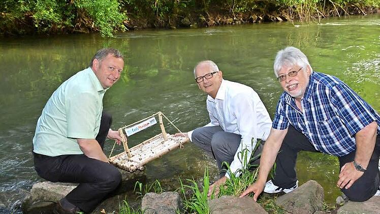 Landrat Thomas Bold, Niederlauers Bürgermeister Richard Kneier und Bad Bocklets Bürgermeister Wolfgang Back lassen traditionell das Saale-Musicum-Floß zu Wasser. Fotos: Björn Hein