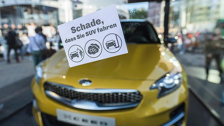 Ein Aufkleber mit der Aufschrift "Schade, dass Sie SUV fahren" klebt während einer Demonstration von Klimaaktivisten vor dem Haupteingang der IAA an einer Scheibe, hinter der ein SUV ausgestellt wird. Foto: Silas Stein/dpa