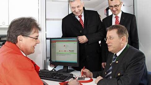 Sparkassen-Fachwirt Jürgen Schaller berät die Kunden. Unser Bild zeigt ihn mit (von links) Sparkassen-Vorstandsvorsitzendem Klaus-Jürgen Scherr, OB Henry Schramm und (dahinter) Sparkassen-Vorstandsmitglied Harry Weiß in der mobilen Zweigstelle.