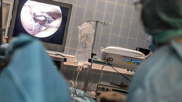Über die winzige Kamera, die Dr. Michael Rüb durch einen kleinen Schnitt in das Schultergelenk führt, sieht er einen losen Faden. Der ist Teil einer gerissenen Naht an der Rotatorenmanschette der Patientin. Rüb entfernt den Faden mit einer Fasszange (siehe Bildschirm).  Fotos: Hendrik Steffens