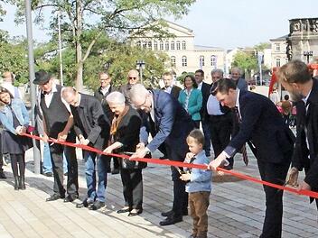 Acht Scheren, achtmal Schnipp-Schnapp - neben Architekten, Vertretern der Stadt, der WSCO und des Landestheaters durften auch ein Kind aus dem Kindergarten Marienhaus und Gertrud Bartelmus (Sechste von rechts), die frühere Betreuerin von Otto Waldrich, das Band durchschneiden und damit den Platz offiziell freigeben. Fotos: Ulrike Nauer