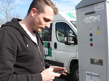 Björn Assel tippt sein Kennzeichen und die gewünschte Parkdauer in sein Smartphone.  Foto: Robert Huger
