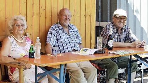 Sitzplatz im Schatten und kühle Getränke - bei sengender Hitze verfolgen diese drei Senioren das Spiel in Pödeldorf vom Logenplatz aus.