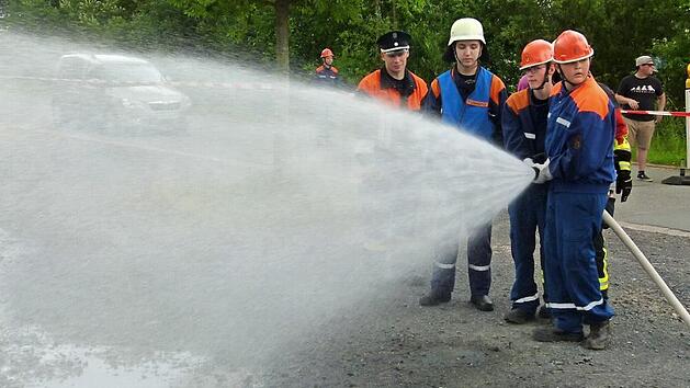 Mit einem kräftigen Wasserstrahl löschen die Jugendlichen den fiktiven Brand einer Gartenhütte. Foto: Doris Weidner