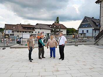 Andreas Schorn (Leiter Bauwesen Markt Pressig), Günther Schubert (SV Rothenkirchen), Jens Fritzsch (Bauleiter), Bürgermeister Hans Pietz (von links) schauen sich den frisch gepflasterten Marktplatz an. Hinten ist der Sockel für das neue Kriegerdenkmal zu sehen sowie die Baustelle der Kreisstraße 9, deren Kurve etwas entschärft wird.  Foto: K.- H. Hofmann