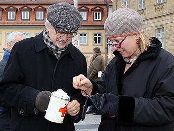 Paul Maar bittet um eine Spende für die Philippinen: Johanne Scharnick gibt dem Kinderbuchautor gerne etwas in die Büchse. Am Samstag sammelten bekannte Bamberger in der Innenstadt für die Taifun-Opfer. Das Geld fließt in Hilfeprojekte des Bayerischen Roten Kreuzes. Foto: Matthias Hoch