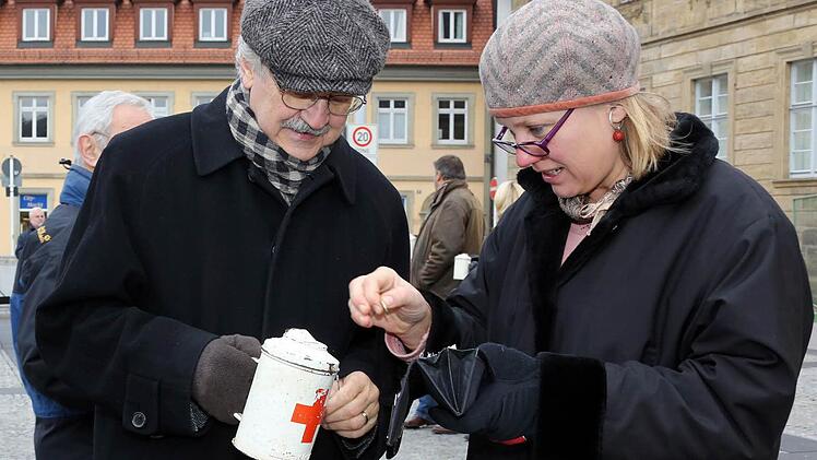 Paul Maar bittet um eine Spende für die Philippinen: Johanne Scharnick gibt dem Kinderbuchautor gerne etwas in die Büchse. Am Samstag sammelten bekannte Bamberger in der Innenstadt für die Taifun-Opfer. Das Geld fließt in Hilfeprojekte des Bayerischen Roten Kreuzes. Foto: Matthias Hoch