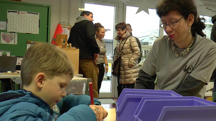 Der vierjährige Linus bemalte seinen "Sausewind", ein Kinderspielzeug, das in der Werkstatt gefertigt wird. Mitarbeiterin Klaudia Karg gab ihm Tipps dazu und bestaunte sein Werk.