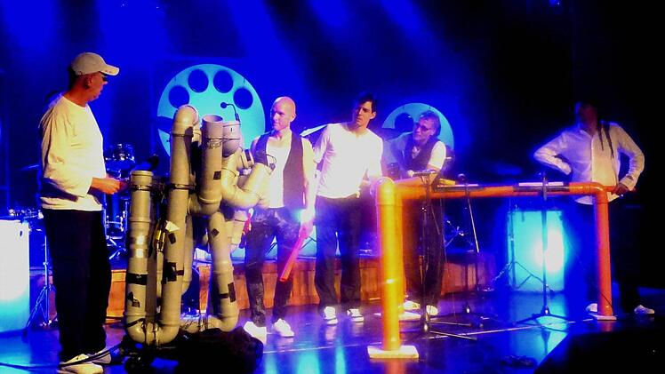 Was hat denn der da für"n Teil? Hannes Eitler mit seinem tönenden Abflussrohr-Monster, bestaunt von seinen Mitspielern Rudi Bauer, Christoph Schmid, Stephan Wildfeuer und Hannes Eitner bei "Power Percussion" im Bad Kissinger Kurtheater. Foto: Ahnert