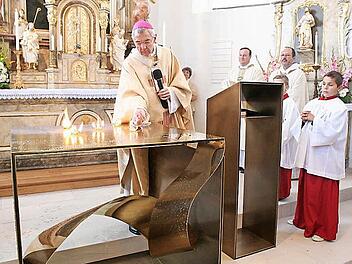 Der Erzibischof entzündet fünf Feuer auf dem Altar. Als Zeichen der Wunden Christie sollen sie zu erkennen sein. Daneben der Abt von Kloster Münsterschwarzach, Michael Reepen, und Pfarrer Albert Müller Foto: See