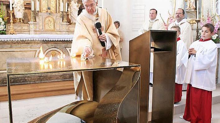 Der Erzibischof entzündet fünf Feuer auf dem Altar. Als Zeichen der Wunden Christie sollen sie zu erkennen sein. Daneben der Abt von Kloster Münsterschwarzach, Michael Reepen, und Pfarrer Albert Müller Foto: See