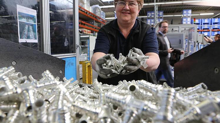 Rund 40 Millionen Fittings jährlich produziert Uponor in Haßfurt. Mitarbeiterin Elia Frank zeigt derartige Verbindungsstücke in T-Form. Foto: Barbara Herbst