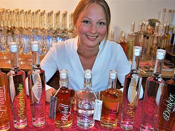 Unterm Quittenbaum: Brennerin Franziska Bischof mit Beispielen ihrer Obstbrände. Im Juli will sie die erste Destillathek Bayerns in Wartmannsroth eröffnen. Foto: Sigismund von Dobschütz