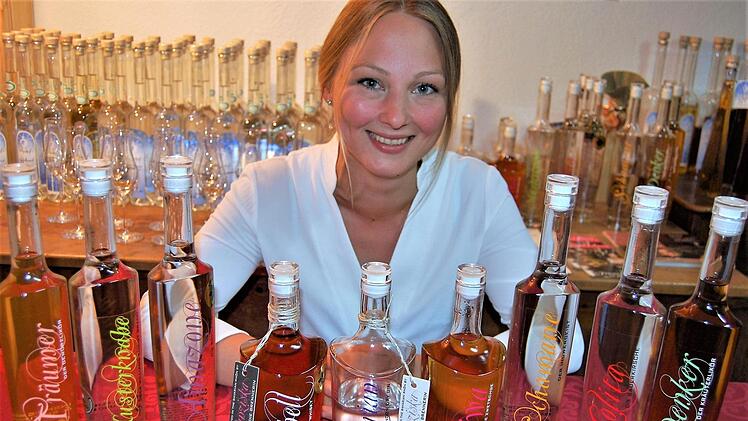 Unterm Quittenbaum: Brennerin Franziska Bischof mit Beispielen ihrer Obstbrände. Im Juli will sie die erste Destillathek Bayerns in Wartmannsroth eröffnen. Foto: Sigismund von Dobschütz