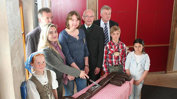 Heinershof-Patin Melanie Huml durfte einen Kuchen in Form eines Schlüssels anschneiden, der anschließend verspeist wurde. Im Bild Bürgermeister Hans Beck, Heinershof-Geschäftsführerin Tina Sickmüller, Landrat, Bezirkstagspräsident Dr. Günther Denzler, Andreas Knorr, Leiter des Landwirtschaftsamtes, sowie die Kinder Sonja Bock, Philipp Luh und Lara Südfeld (von links)