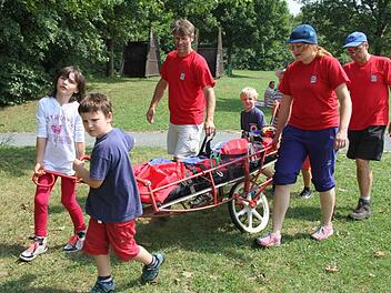 Mit einer fahrbaren Trage kann die Bergwacht Kulmbach Menschen auch aus schwierigem Gelände retten - an der Kieswäsch durften interessierte Kinder ausprobieren, was damit alles möglich ist. Fotos: Sonja Adam