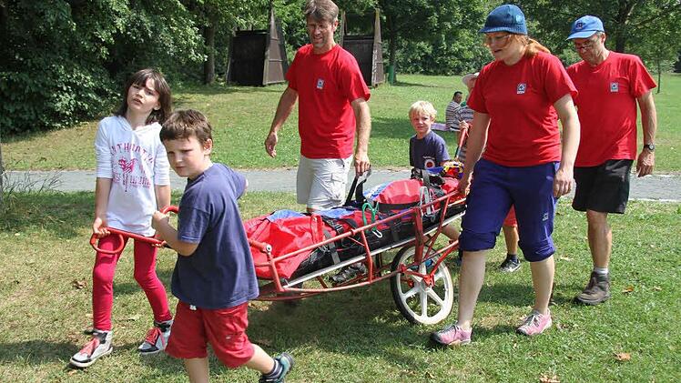 Mit einer fahrbaren Trage kann die Bergwacht Kulmbach Menschen auch aus schwierigem Gelände retten - an der Kieswäsch durften interessierte Kinder ausprobieren, was damit alles möglich ist. Fotos: Sonja Adam